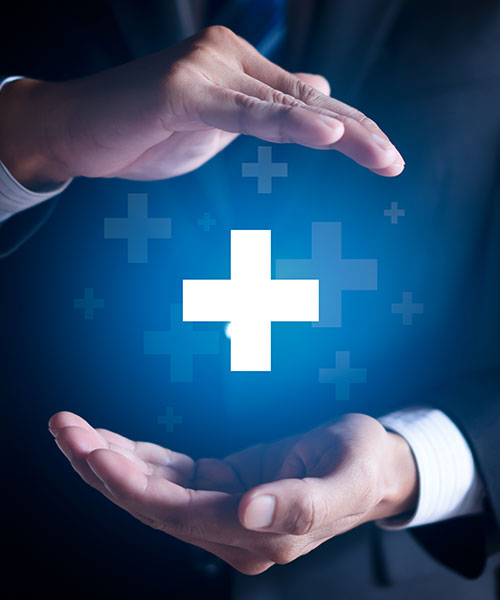 Hands holding a plus symbol to represent insurance